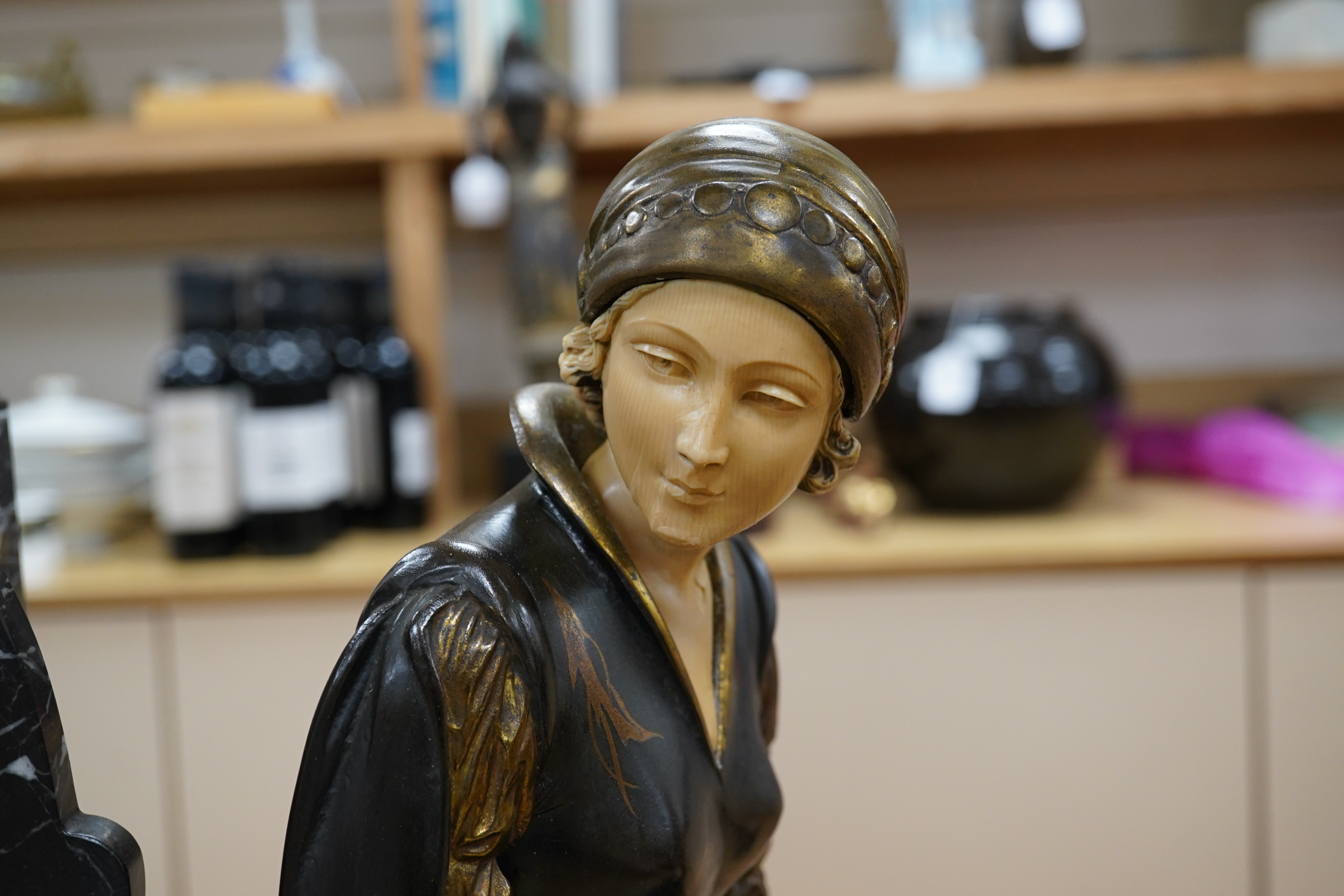 A French Art Deco black and white marble clock, with an ornately painted Spelter figure of a seated lady, width 62cm. Condition - good, unknown if clock in working order